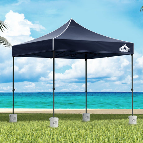 Navy 3 x 3 m pop up gazebo with four base pods set up outdoors