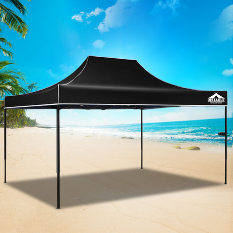 Black pop up gazebo folded down to its compact size for transport