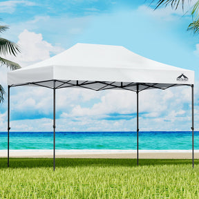 White 4.5 x 3 m pop up gazebo set up on grass with open sides