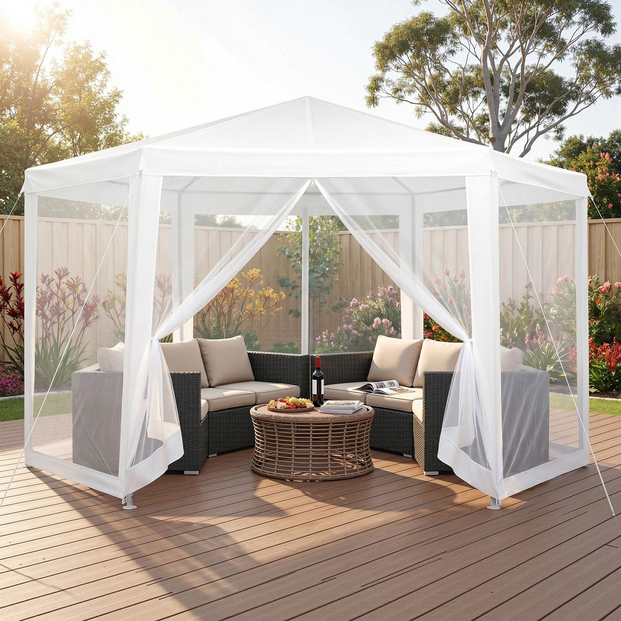 White hexagonal gazebo with mesh walls set up on grass for an outdoor party