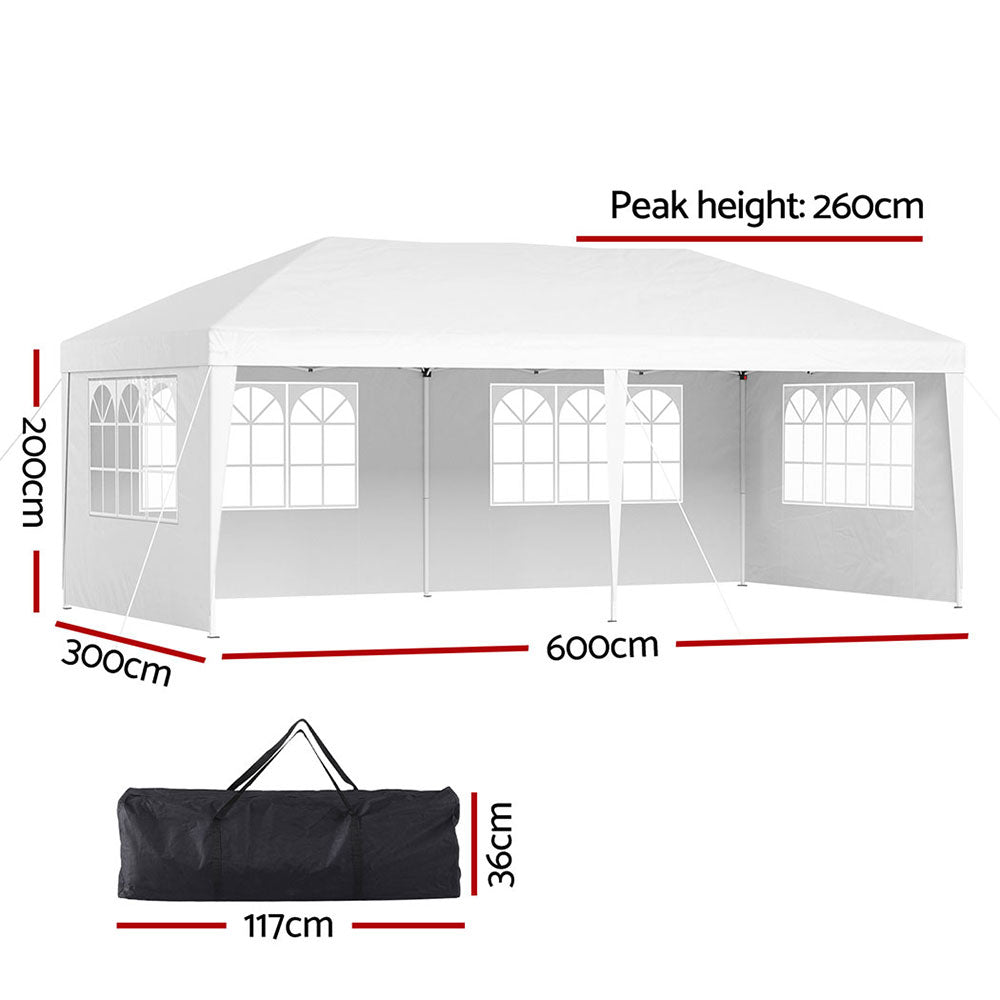 Angled view of the white marquee tent showing the peaked roof and side wall windows