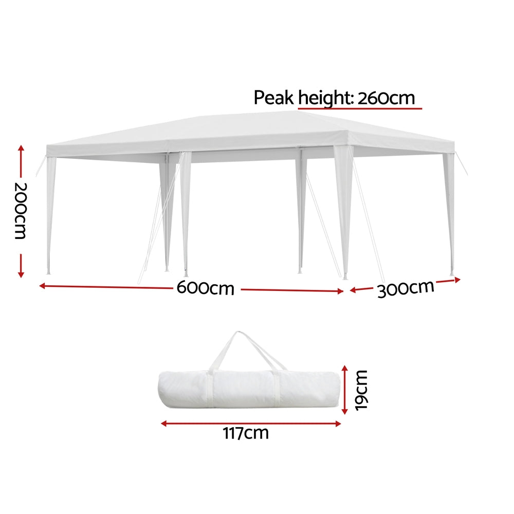 White marquee gazebo shading an outdoor wedding seating area