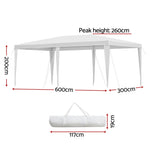 White marquee gazebo shading an outdoor wedding seating area