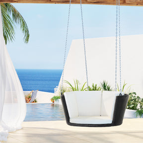 Tianjara rattan outdoor swing chair with woven wicker seat and chains in a backyard