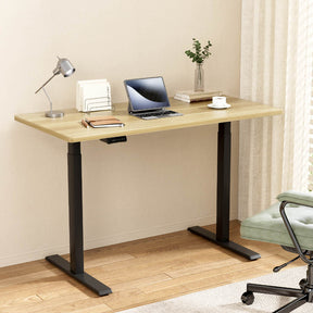 Manuka oak electric standing desk with black frame in a home office