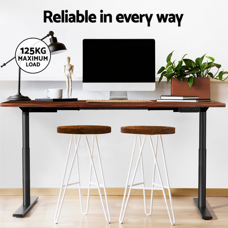 Braddon rustic brown electric standing desk with black frame in a home office