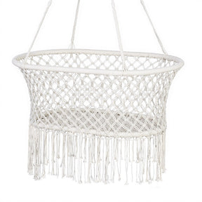 Canouan cream cotton blend hammock swing chair with mesh net and tassels in a garden