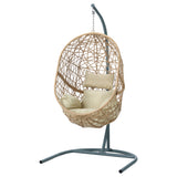 Vincentia yellow resin wicker hanging egg chair with stand on a patio