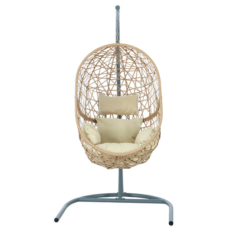 Vincentia yellow resin wicker hanging egg chair with stand on a patio