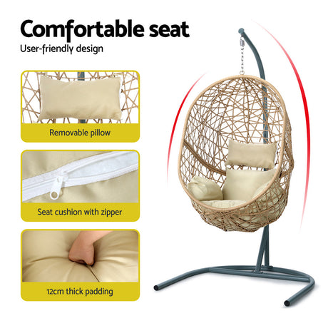 Vincentia yellow resin wicker hanging egg chair with stand on a patio