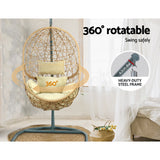 Vincentia yellow resin wicker hanging egg chair with stand on a patio
