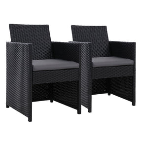 Coila black wicker outdoor dining chairs with foldable backrests and cushions on a patio