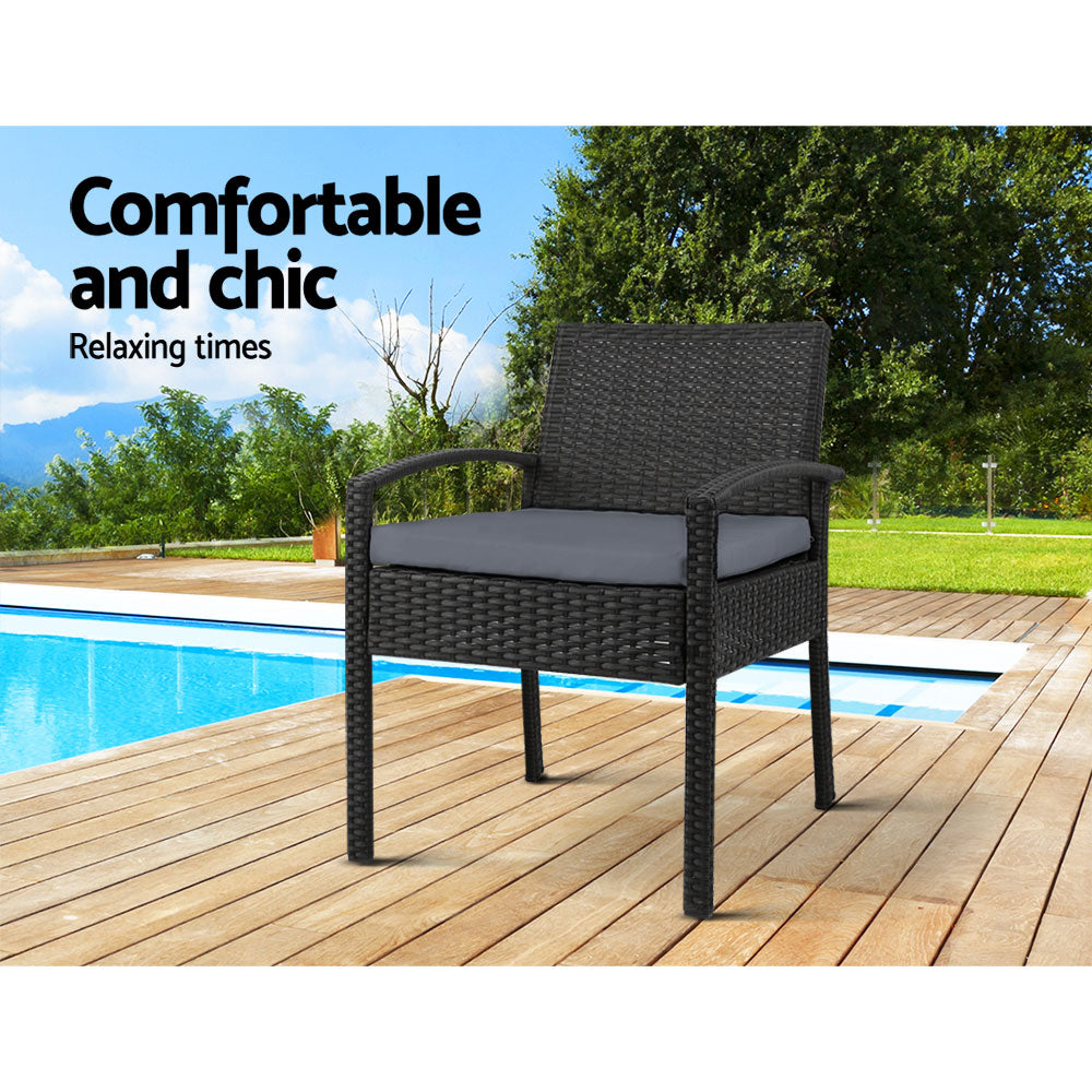 Ulladulla pair of black PE wicker outdoor dining chairs with cushions on a patio
