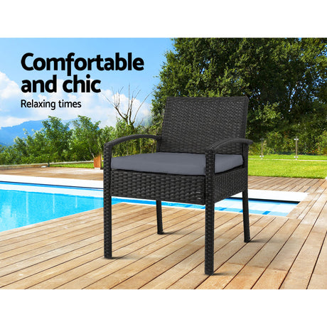 Ulladulla pair of black PE wicker outdoor dining chairs with cushions on a patio