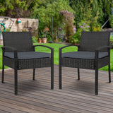 Ulladulla pair of black PE wicker outdoor dining chairs with cushions on a patio