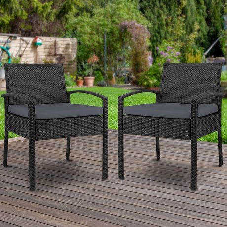 Ulladulla pair of black PE wicker outdoor dining chairs with cushions on a patio