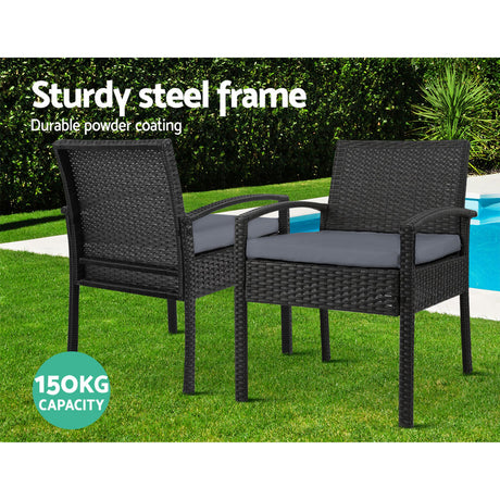 Ulladulla pair of black PE wicker outdoor dining chairs with cushions on a patio