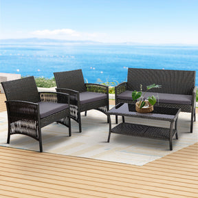 Tathra dark grey wicker outdoor sofa set with curved design and tempered glass table on a patio
