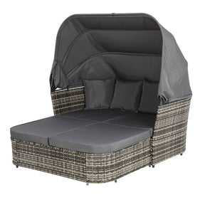 Kianga grey wicker outdoor daybed with adjustable canopy and cushions in a garden