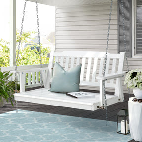 Gerroa white wooden porch swing chair with fir wood slats hanging on a porch