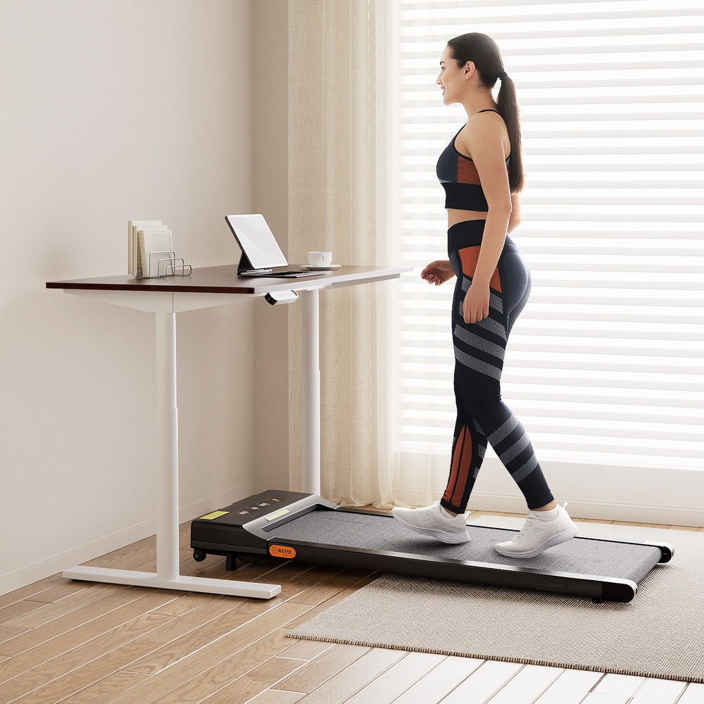 Deakin walnut electric standing desk with walking pad in a home office