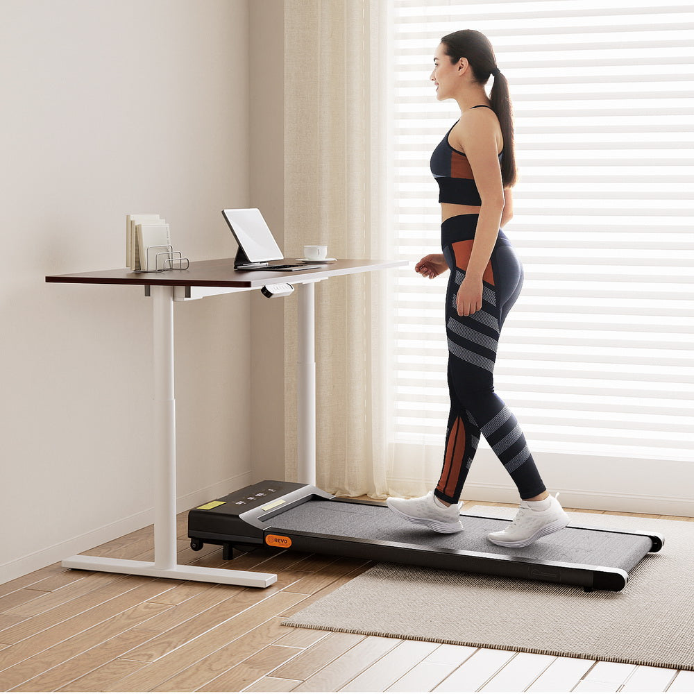 Deakin walnut electric standing desk with walking pad in a home office