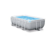 Rectangular above ground metal frame swimming pool with filter pump in a backyard