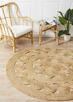 Qum natural jute hand braided area rug in a living room