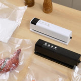 Black cordless vacuum sealer shown with vacuum bags ready for sealing