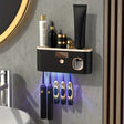 Olbia wall mounted toothbrush organiser in black and gold with toothpaste dispenser