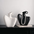 Two ceramic human form vases, one matte black and one white