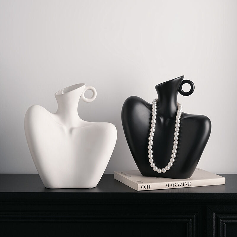 Two ceramic human form vases, one matte black and one white