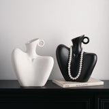 Two ceramic human form vases, one matte black and one white