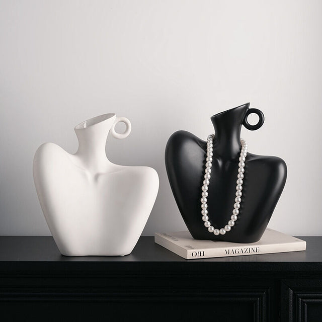 Two ceramic human form vases, one matte black and one white