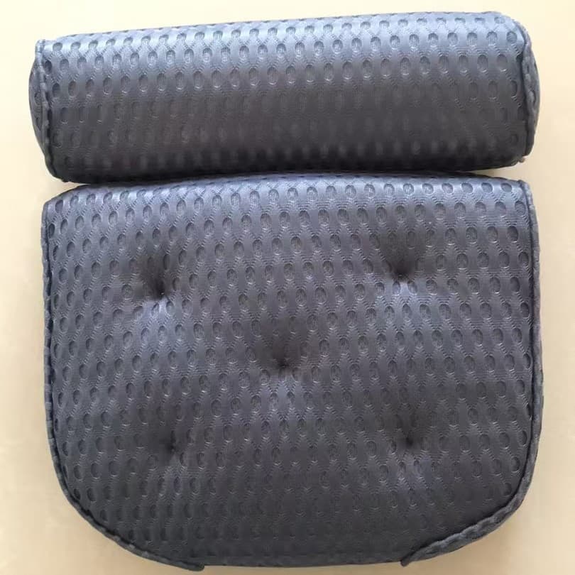 Blue bath pillow suctioned to a smooth bathtub surface