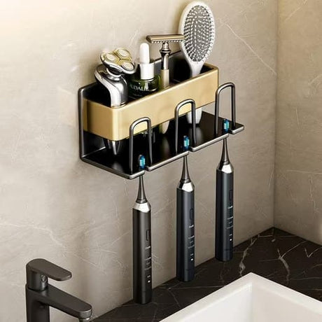 Gold wall mounted rack holding three toothbrushes in its slots with the cup below