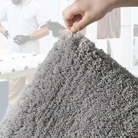 Large grey microfibre bath mat placed beside a bath for stepping out