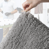 Large dark beige microfibre bath mat placed beside a bath for stepping out