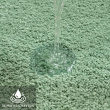 U shaped sage green contour rug fitted around the base of a toilet