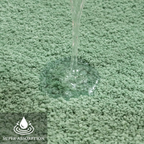 U shaped sage green contour rug fitted around the base of a toilet