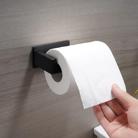 Adhesive pad on the back of the black toilet paper holder