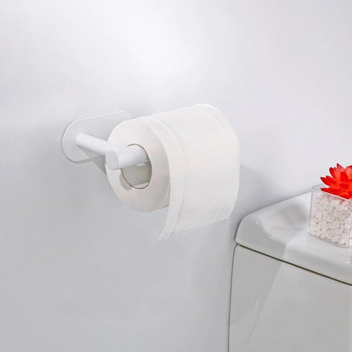 Adhesive backing of the white toilet roll holder shown before no drill installation