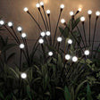 Cool white solar firefly lights in decorative pots along a garden path