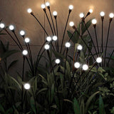 Cool white solar firefly lights in decorative pots along a garden path