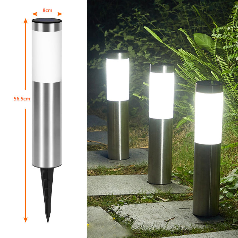 Cylindrical stainless steel solar path light staked along a garden aisle