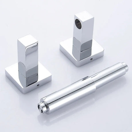 Chrome toilet paper holder mounted on a bathroom wall beside a toilet
