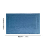 White cotton floor towel bath mat placed beside a bath tub