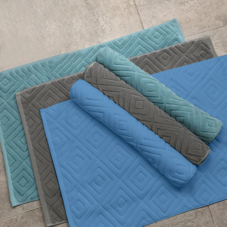 Two pack of white absorbent cotton bath mats folded and stacked
