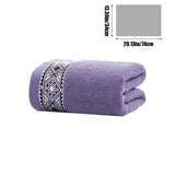 Cotton bath towel folded and stacked on a bathroom shelf