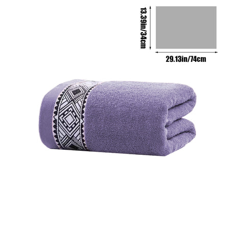 Cotton bath towel folded and stacked on a bathroom shelf